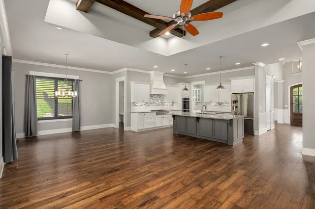 a view of kitchen with kitchen island wooden floor center island and stainless steel appliances