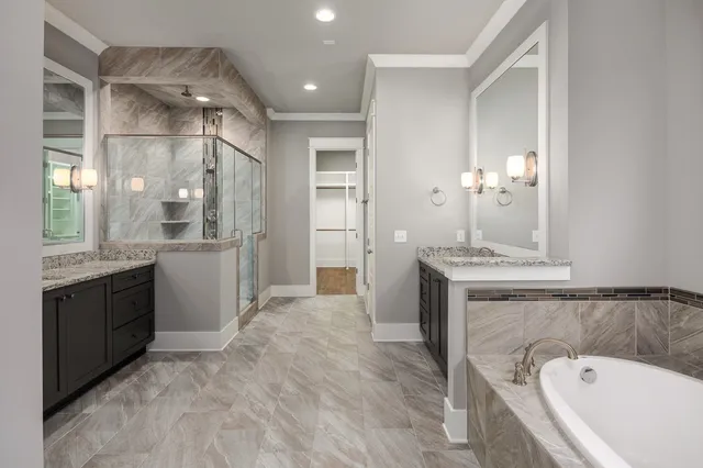a spacious bathroom with a granite countertop sink a mirror and a bathtub