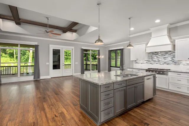 a kitchen with stainless steel appliances granite countertop a sink and wooden floor