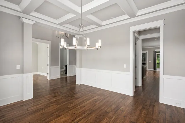 a view of a hallway with wooden floor and chandelier