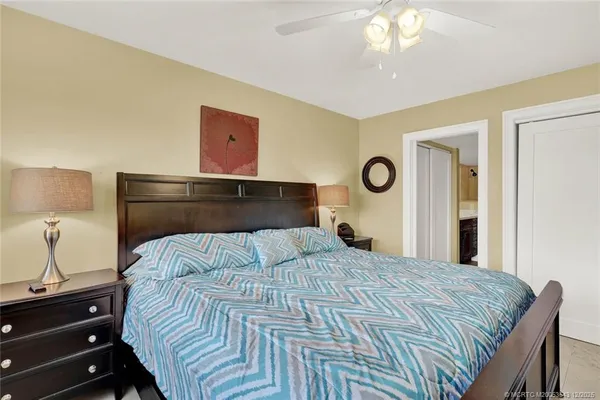 a bedroom with a bed and a lamp on dresser