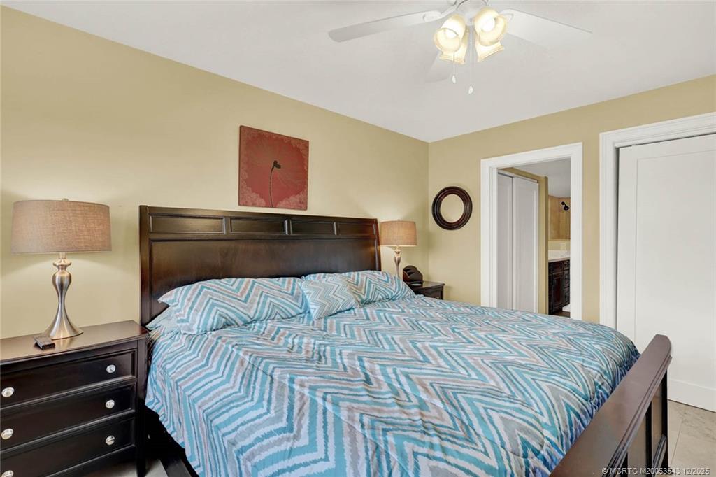 40 Northeast Plantation Road, Unit 101 Stuart, FL 34996 - Photo 16 of 37 a bedroom with a bed and a lamp on dresser