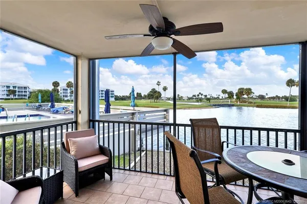 a view of a chairs and table in patio with a lake view