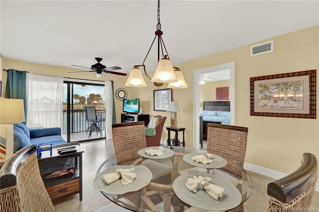 40 Northeast Plantation Road, Unit 101 Stuart, FL 34996 - Photo 7 of 37 a dining room with furniture a rug and a chandelier