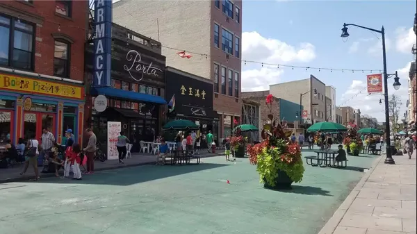 a group of people standing around a fruit stand