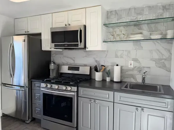 a kitchen with stainless steel appliances a stove a microwave and refrigerator