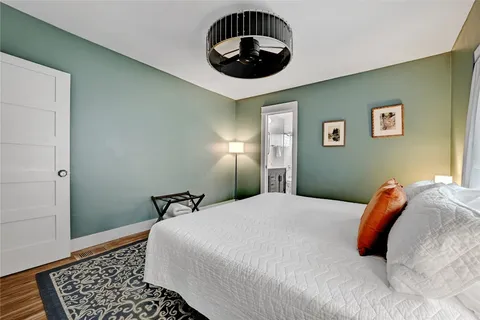 a bedroom with a bed and a painting on the wall