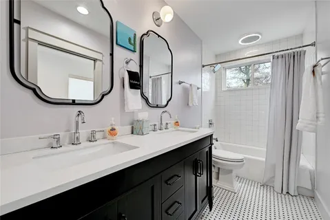 a bathroom with a sink a toilet and a mirror