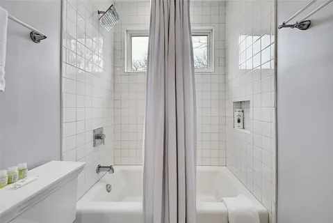 a bathroom with a tub shower vanity and a sink