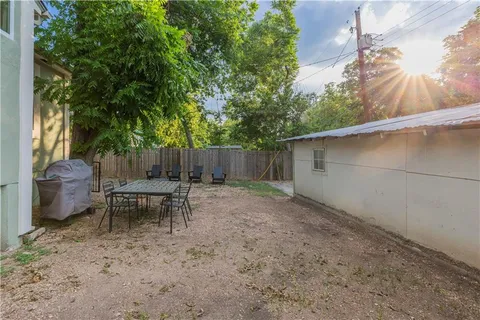a backyard of a house with table and chairs