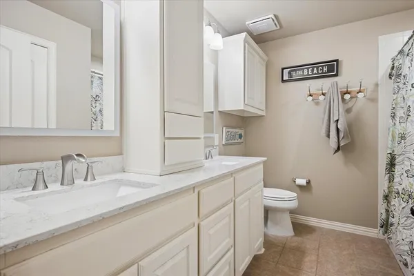 a bathroom with a granite countertop sink a toilet and a mirror