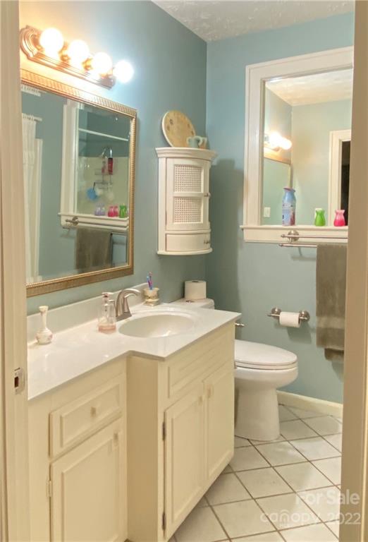 19 Osborne Road Asheville, NC 28804 - Photo 18 of 35 a bathroom with a granite countertop sink mirror vanity and toilet