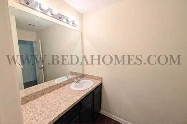 a bathroom with a granite countertop sink and a mirror