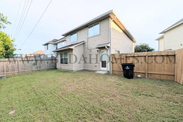 a front view of a house with a yard and potted plants