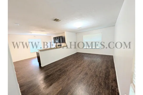 a view of a room with wooden floor and furniture