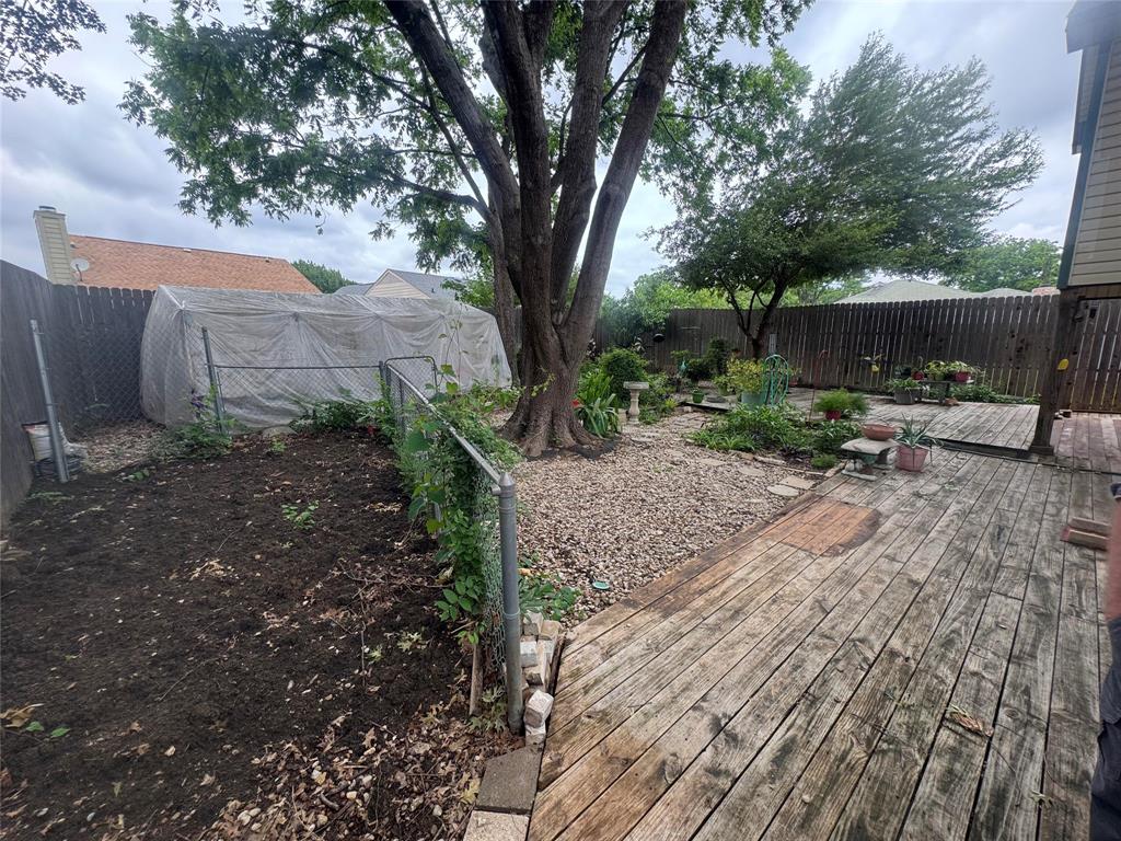 4649 Misty Ridge Drive Fort Worth, TX 76137 - Photo 13 of 25 a backyard of a house with a large tree and wooden fence