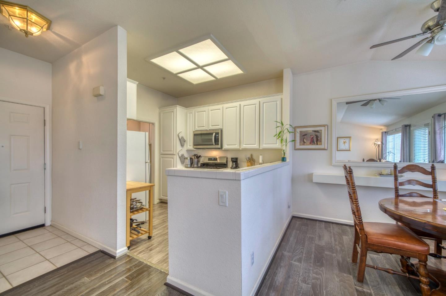 121 Skyline Drive San Ramon, CA 94583 - Photo 10 of 38 a kitchen with stainless steel appliances kitchen island granite countertop a refrigerator a stove a sink a dining table and chairs with wooden floor