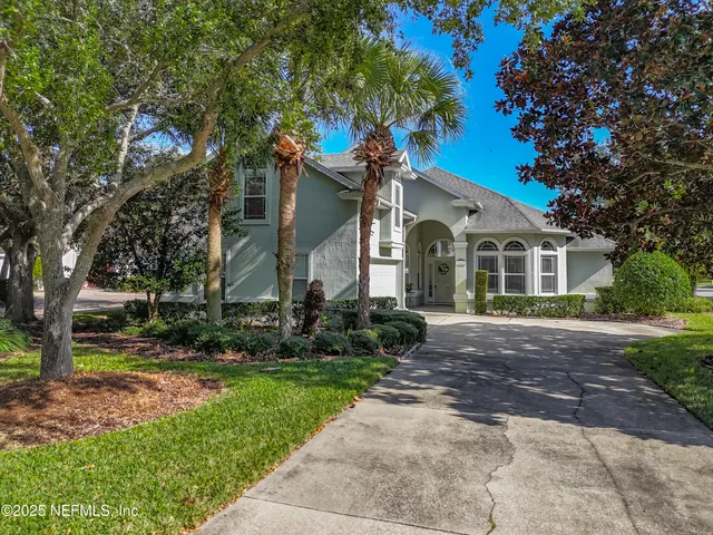 a front view of a house with a yard and trees