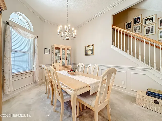 a view of a dining room with furniture and chandelier