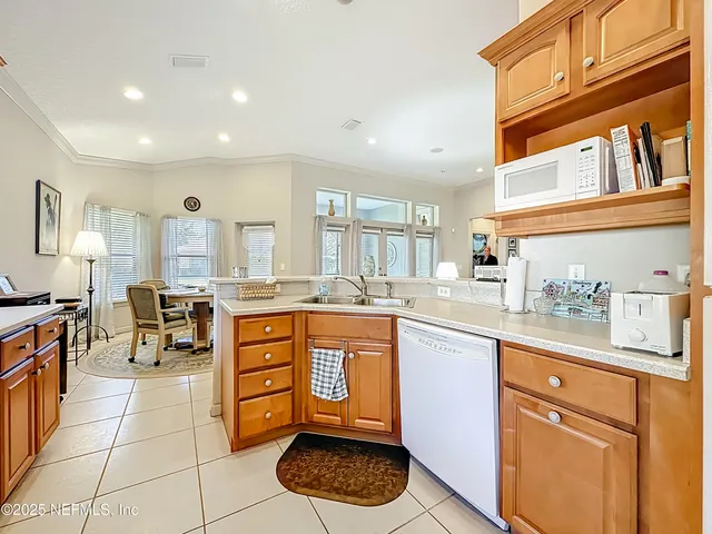a large kitchen with stainless steel appliances granite countertop a large stove a sink and a white cabinets
