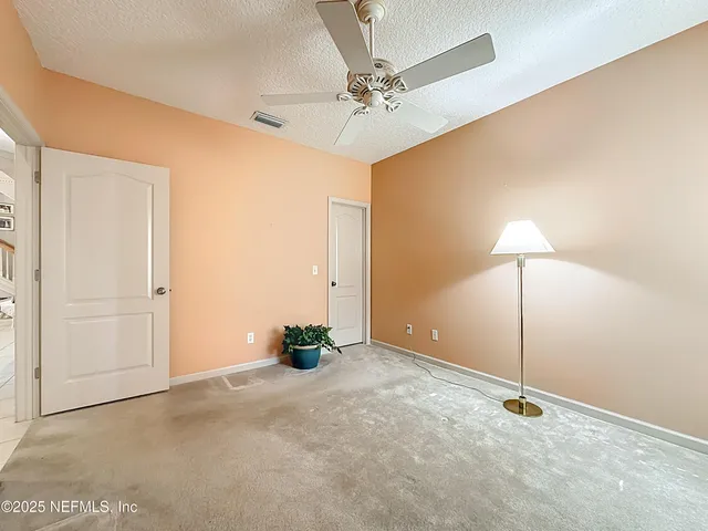 a view of a livingroom with a chandelier fan and a window