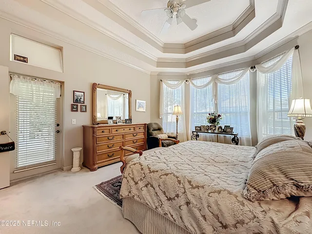 a bedroom with a bed mirror and a chandelier