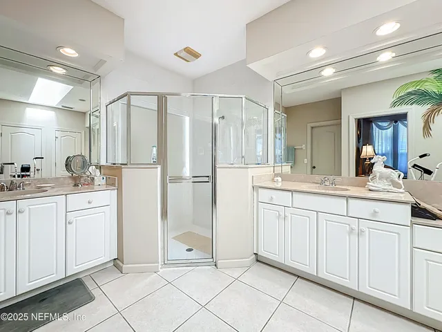 a spacious bathroom with a granite countertop sink a mirror and next to a window