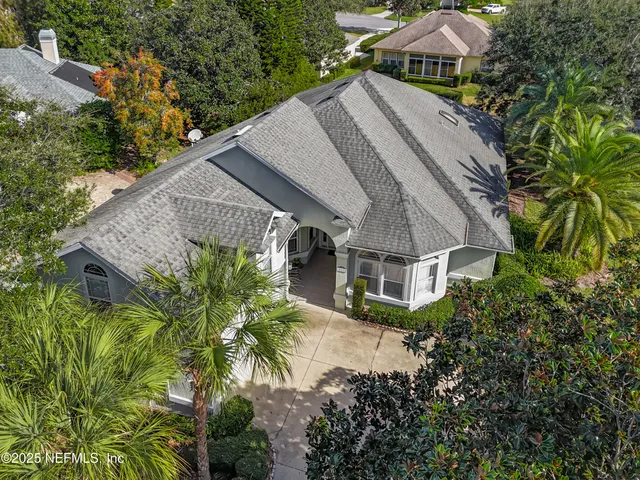 an aerial view of house with yard and trees in the background