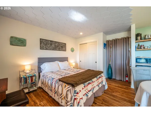 a bedroom with a bed and wooden floor