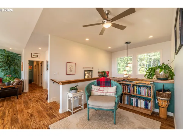 a living room with furniture large windows and wooden floor