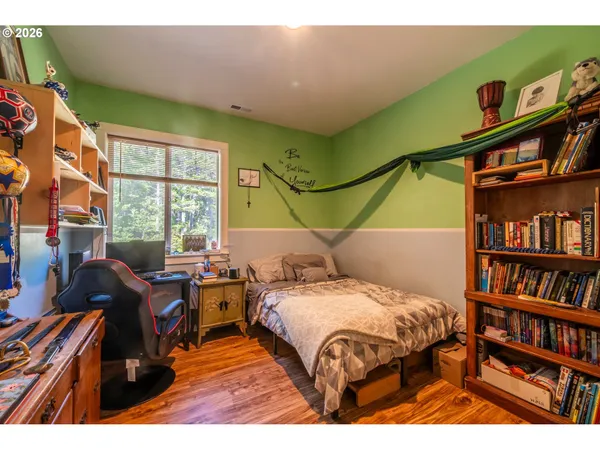 a bedroom with a bed and wooden floor