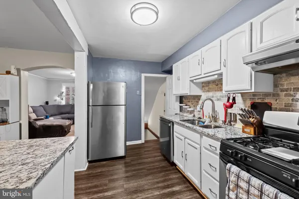 a kitchen with stainless steel appliances granite countertop a stove a refrigerator and a sink