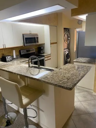a kitchen with kitchen island granite countertop a stove and a sink