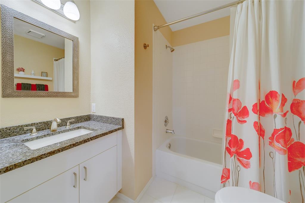 4405 Connery Court Palm Harbor, FL 34685 - Photo 31 of 51 a bathroom with a granite countertop sink mirror and a bathtub