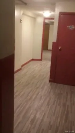 a view of a hallway with wooden floor and entryway