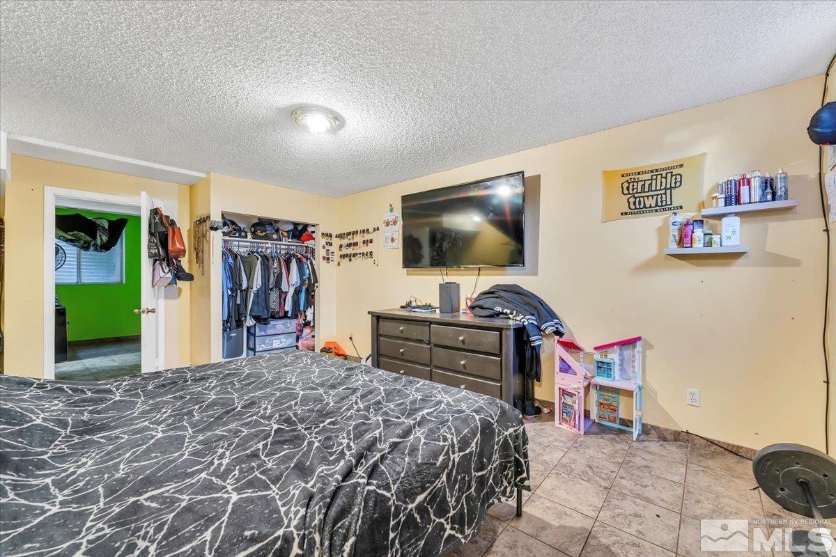 1402 East 9th Street, Unit 11 Reno, NV 89512 - Photo 18 of 25 a bedroom with a bed and a flat screen tv