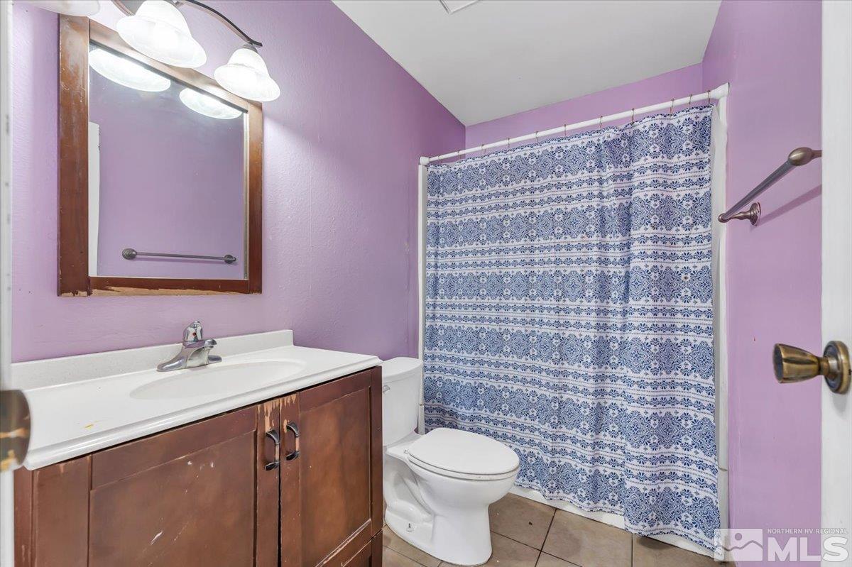 1402 East 9th Street, Unit 11 Reno, NV 89512 - Photo 8 of 25 a bathroom with a sink a toilet and shower curtain