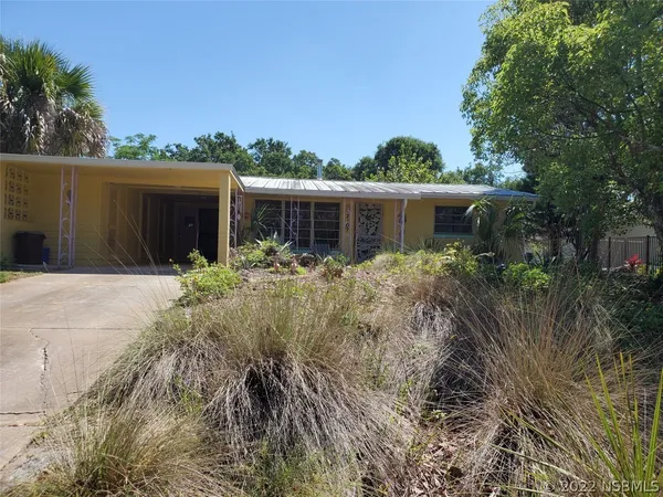 a front view of house with yard and trees around