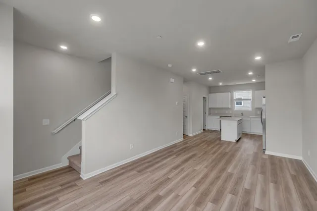 a view of a living room hardwood floor and a kitchen