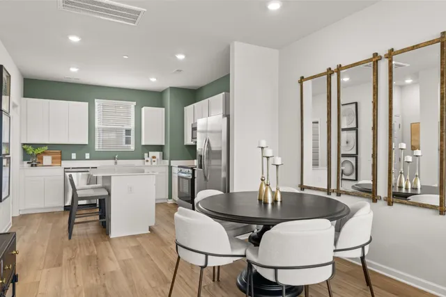 a kitchen with a table chairs refrigerator and cabinets