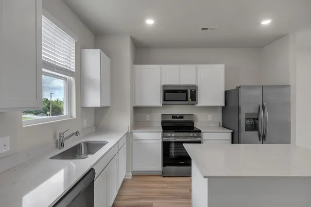 a kitchen with stainless steel appliances a stove sink microwave and refrigerator