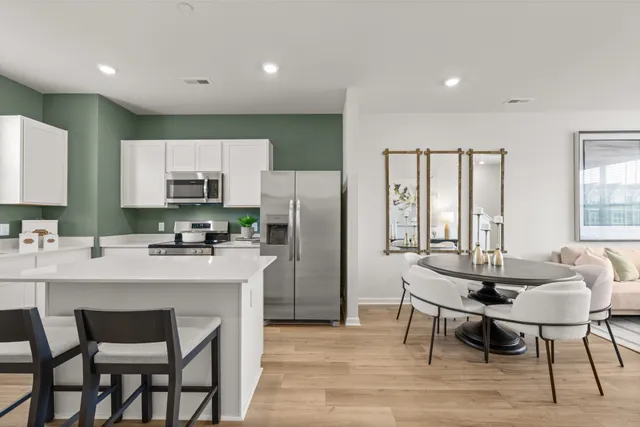 a kitchen with stainless steel appliances a dining table chairs microwave and sink