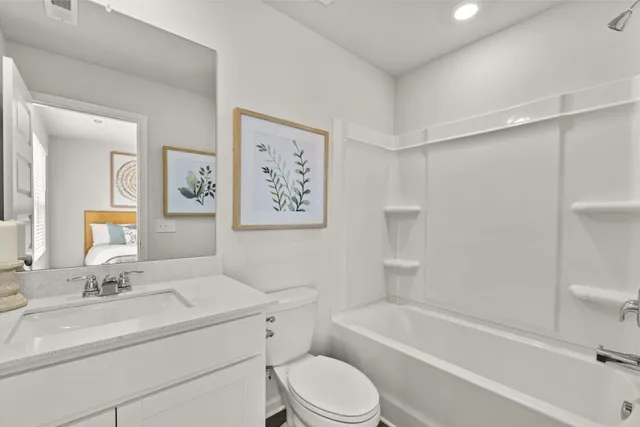 a bathroom with a bathtub shower sink vanity and toilet