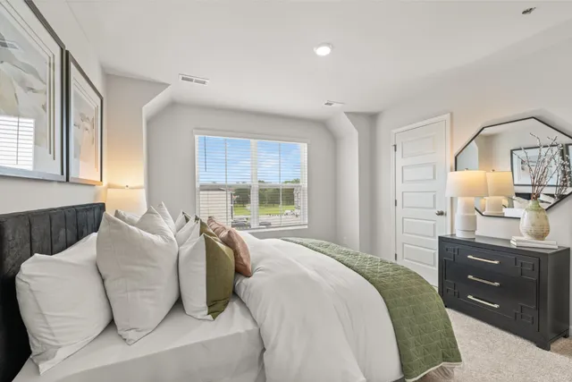 a bedroom with a bed and painting on the wall