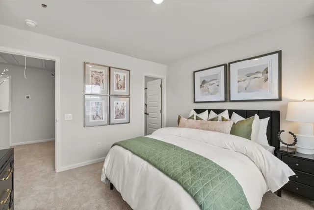 a bedroom with a bed and dresser with mirror