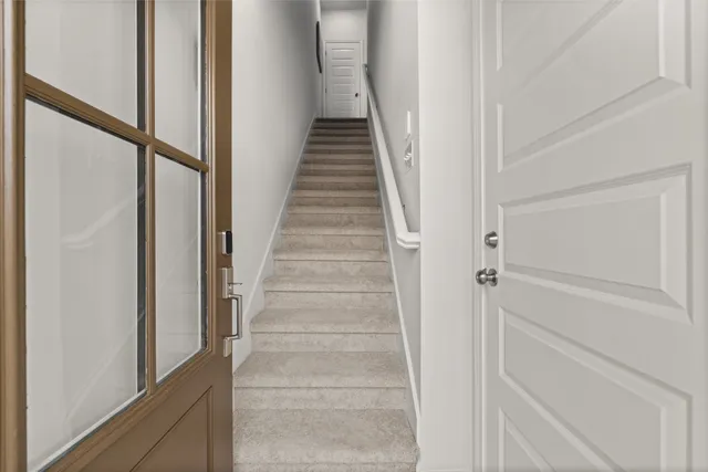 a view of staircase with white walls and white door