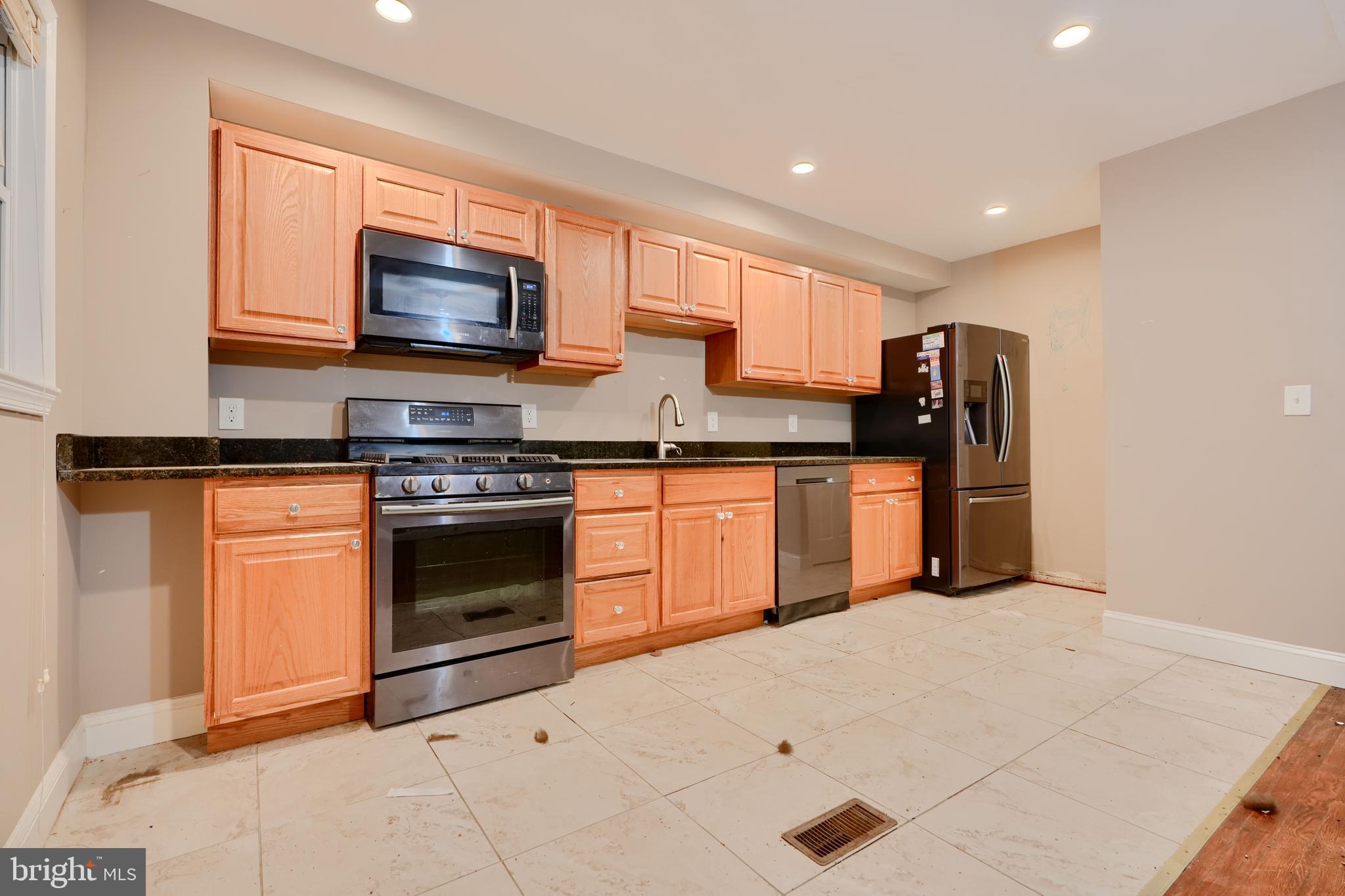 8037 North Boundary Road Dundalk, MD 21222 - Photo 11 of 36 a kitchen with stainless steel appliances granite countertop a stove top oven and sink