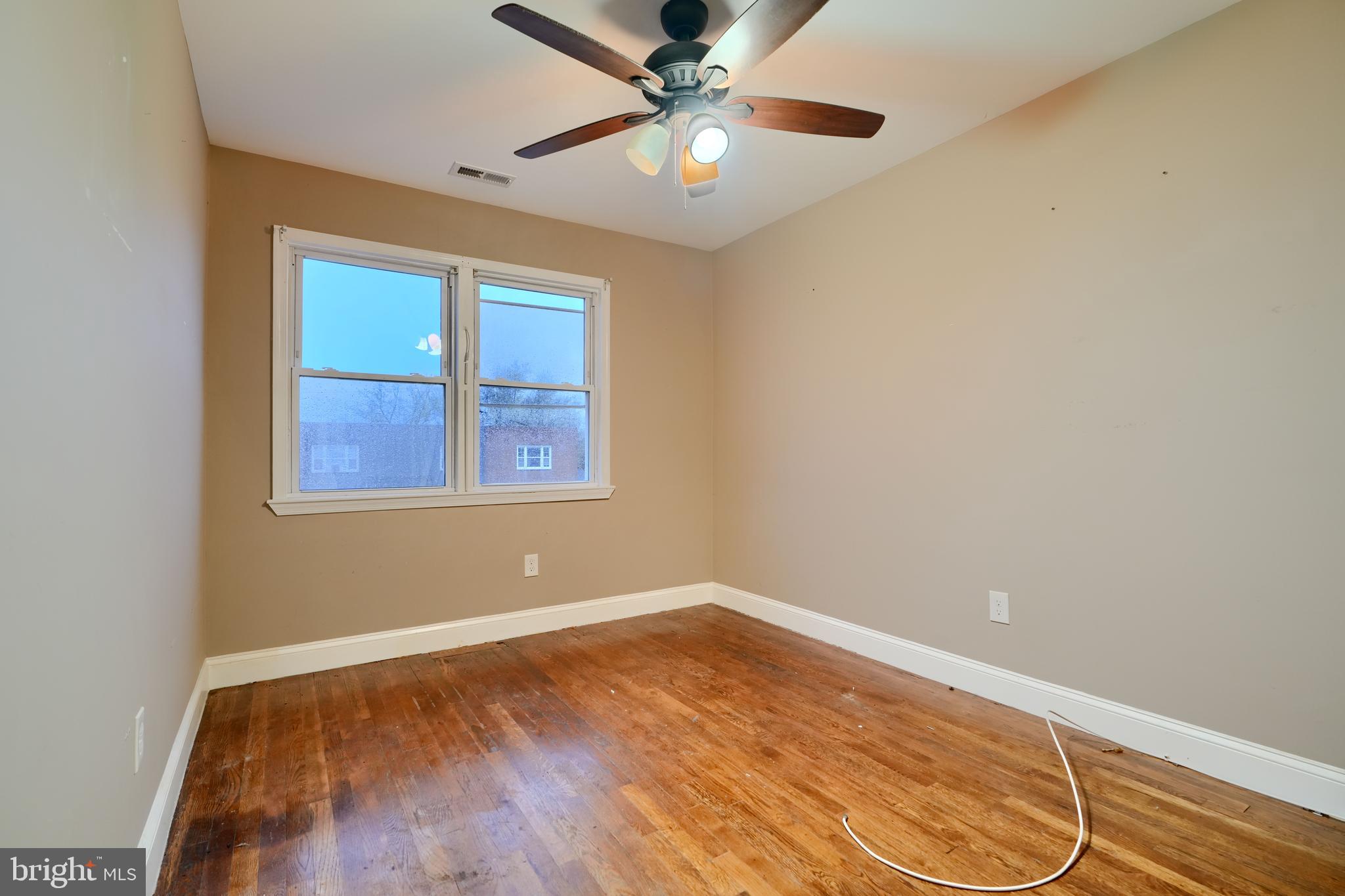 8037 North Boundary Road Dundalk, MD 21222 - Photo 17 of 36 an empty room with wooden floor fan and windows
