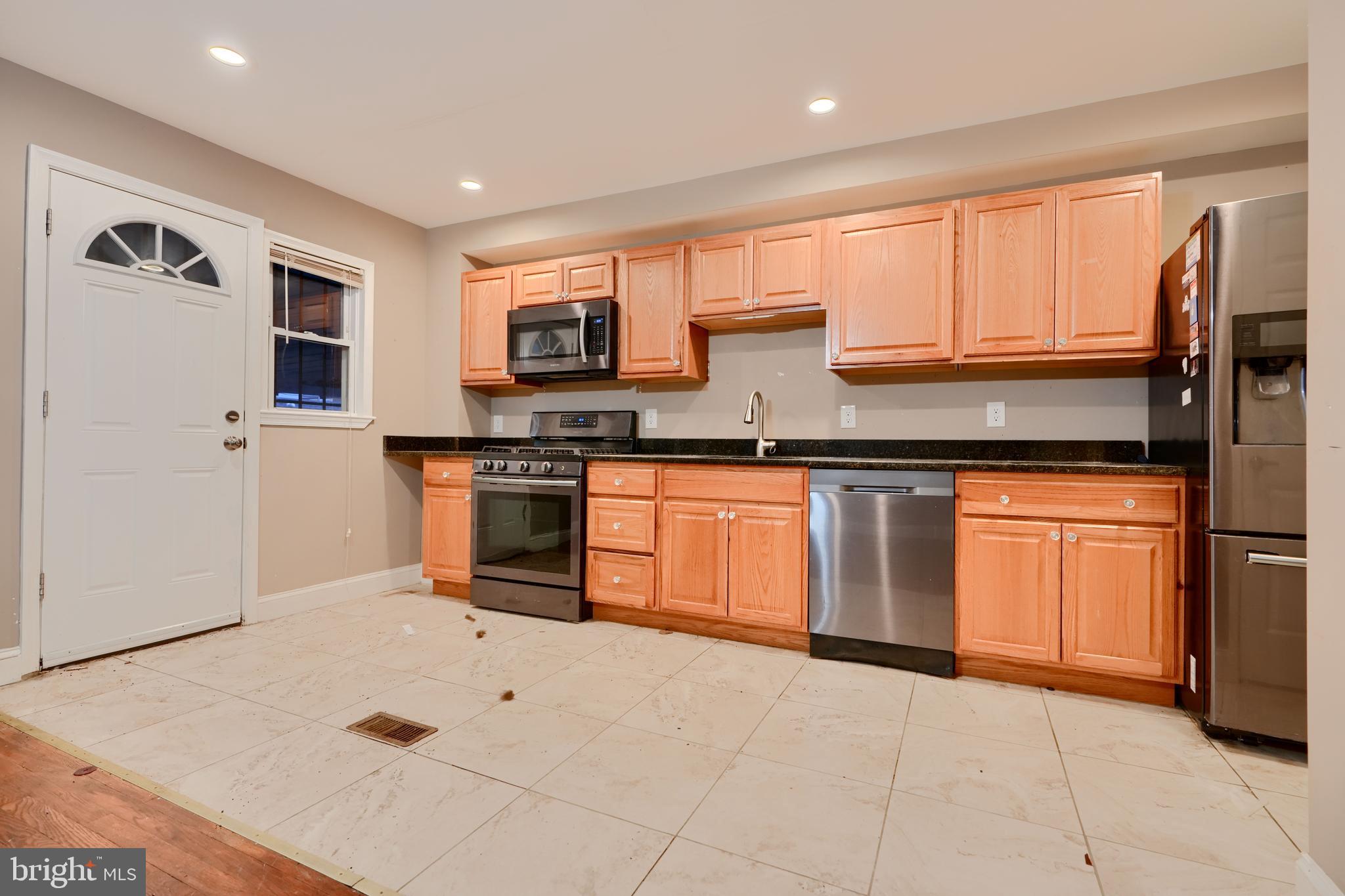 8037 North Boundary Road Dundalk, MD 21222 - Photo 10 of 36 a kitchen with stainless steel appliances granite countertop a stove top oven a sink a counter space and cabinets