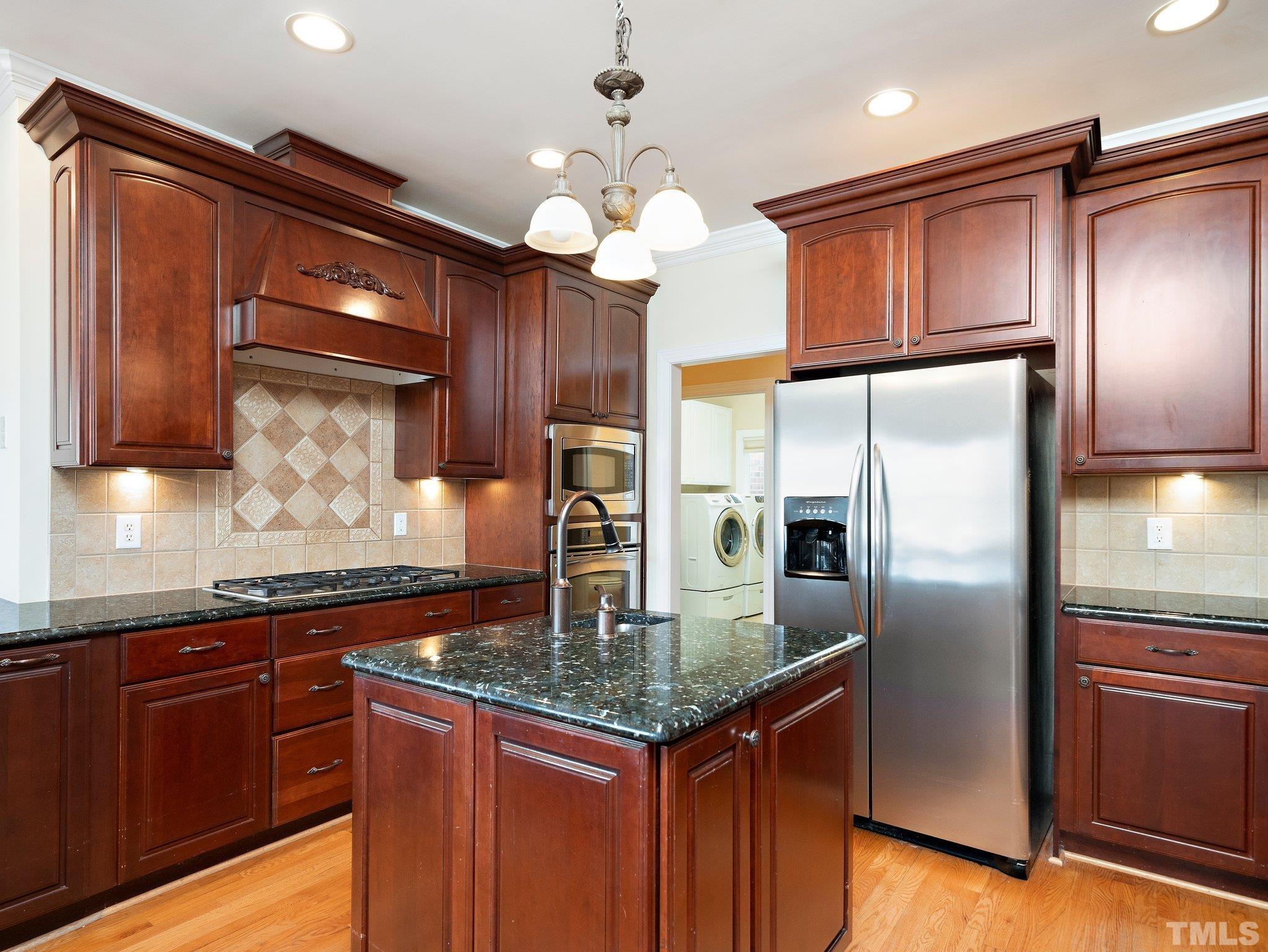 619 Competition Road Raleigh, NC 27603 - Photo 11 of 28 a kitchen with stainless steel appliances granite countertop a refrigerator a sink dishwasher a oven with wooden cabinets and floor